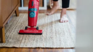Professional technician extracting dirty water from a carpet using heavy steam wand