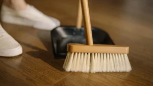 Professional cleaner sweeping dust off balcony tiled floor