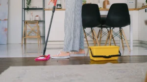 Professional housekeeper mopping marble tiles in a bright home hallway
