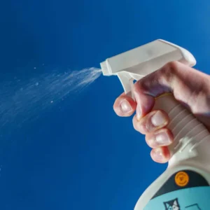 Technician spraying anti-mite protective spray on mattress surface in Dubai