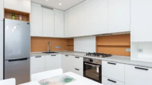 Professional inspector checking empty kitchen cabinets in a clean apartment