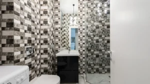 Professional cleaner using descaling spray to clean calcium marks off shower glass