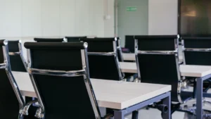 A commercial cleaner cleaning conference room after corporate meeting