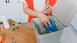 An evening janitor emptying office waste bin and wiping office desks