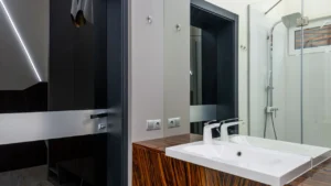 A janitor sanitizing office toilets and bathroom mirrors