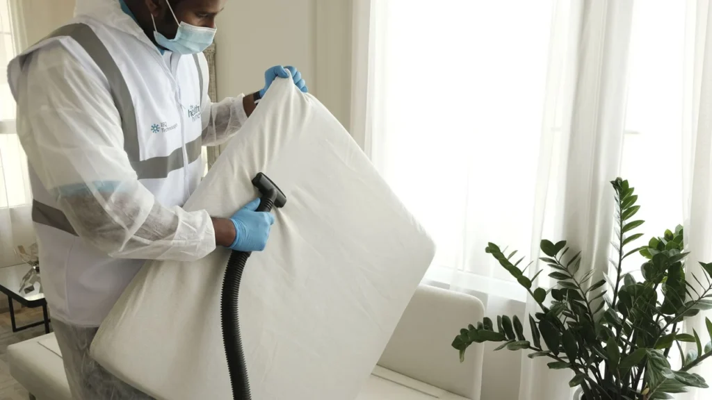 Mattress technician steam sanitizing a large mattress in a bedroom in Dubai