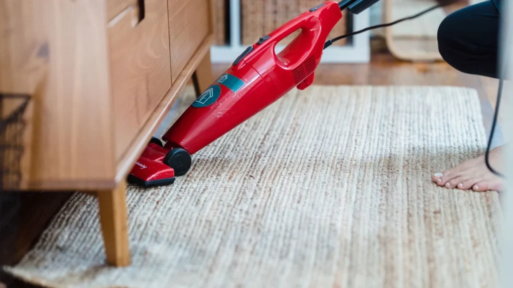 Cleaner vacuuming empty wooden wardrobes and shelves during move out cleaning in Dubai