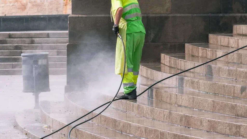 Professional cleaning team pressure washing a luxury Dubai villa outdoor driveway