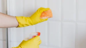 Professional cleaner wiping drywall plaster residues from villa baseboards